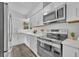 Modern kitchen featuring white cabinetry, stainless steel appliances, and quartz countertops at 1161 Ramble Ave, Deltona, FL 32725