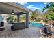 A covered patio offers an ideal space for outdoor seating with views of a swimming pool and manicured landscaping at 13315 Sproston Pt, Orlando, FL 32832