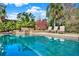 A sparkling swimming pool with a waterfall feature and lounge chairs on the pool deck at 13315 Sproston Pt, Orlando, FL 32832