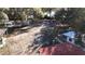 Aerial view of the property with multiple outbuildings surrounded by large trees and some waterfront at 1343 Spring Lake Rd, Fruitland Park, FL 34731