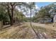 Large, treed backyard with multiple covered areas for parking or storage and lush landscaping at 1343 Spring Lake Rd, Fruitland Park, FL 34731