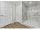 Modern bathroom featuring a walk-in shower with marble tile and wood floor at 1343 Spring Lake Rd, Fruitland Park, FL 34731