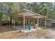 Open carport structure with wooden beams and support columns in a backyard setting at 1343 Spring Lake Rd, Fruitland Park, FL 34731