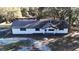 Aerial view of a single-story home with fresh exterior paint surrounded by mature trees and a large yard at 1343 Spring Lake Rd, Fruitland Park, FL 34731