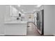 Modern kitchen features white cabinetry, stainless steel appliances, wood floor, and quartz countertops at 1343 Spring Lake Rd, Fruitland Park, FL 34731