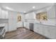 Bright kitchen features stainless steel appliances, wood floor, white cabinetry, and quartz countertops at 1343 Spring Lake Rd, Fruitland Park, FL 34731