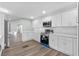 Bright kitchen features stainless steel appliances, wood floor, white cabinetry, and quartz countertops at 1343 Spring Lake Rd, Fruitland Park, FL 34731