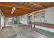 Interior of a workshop showing a concrete floor, wood beams, walls, windows and a green entry door at 1343 Spring Lake Rd, Fruitland Park, FL 34731
