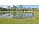 Scenic view of the backyard pond reflecting trees on a sunny day at 1412 Captiva Cv, Sanford, FL 32771