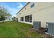 A large backyard with green grass and the house's exterior with screen patio visible at 157 Primrose Dr, Davenport, FL 33837