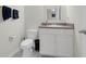 Cozy half bathroom featuring modern fixtures, including a toilet and sink, with dark blue hand towels hanging at 157 Primrose Dr, Davenport, FL 33837