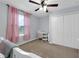 Bright bedroom featuring a ceiling fan, closet, and window with pink curtains at 157 Primrose Dr, Davenport, FL 33837