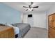 Neutral-toned bedroom with a mounted TV, ceiling fan, closet, and cozy carpeted flooring at 157 Primrose Dr, Davenport, FL 33837