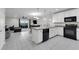 Modern kitchen with a view of the living room, featuring stainless steel appliances and tile flooring at 157 Primrose Dr, Davenport, FL 33837
