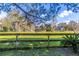 Scenic backyard view with green grass, a rustic wooden fence, and glimpse of a lake at 1821 Myrtle Lake Hills Rd, Longwood, FL 32750