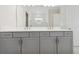 Elegant bathroom with double vanity, gray cabinets, quartz countertop, and large mirror at 2120 Antilles Club Dr # 10, Kissimmee, FL 34747
