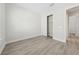 Bright bedroom featuring light gray walls, vinyl plank flooring, closet, and access to other rooms at 2120 Antilles Club Dr # 10, Kissimmee, FL 34747