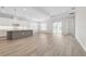 Open-concept living space with a kitchen island, sliding glass doors, and light wood-look flooring at 2120 Antilles Club Dr # 10, Kissimmee, FL 34747
