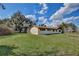 Backyard view with a well-maintained lawn, house, and mature trees on a sunny day at 2450 Nela Ave, Belle Isle, FL 32809