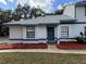 Charming one story home with a minimalist landscaped yard, front windows, and a blue entry door at 2652 Graduate Ct, Orlando, FL 32826
