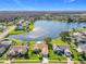 Aerial view of lakeside homes with pools and well-maintained lawns near a lush forest at 2732 Lone Feather Dr, Orlando, FL 32837