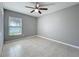 Neutral bedroom featuring a ceiling fan, tile flooring, and a window with natural light at 2732 Lone Feather Dr, Orlando, FL 32837