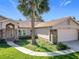 Attractive home exterior with a brick accent wall, manicured lawn, and an attached two-car garage at 2732 Lone Feather Dr, Orlando, FL 32837