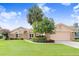 Lovely single-Gathering home with a lush green lawn, mature landscaping, and a two-car garage at 2732 Lone Feather Dr, Orlando, FL 32837
