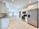 Bright kitchen features stainless steel appliances, white cabinetry, and a spacious center island at 2732 Lone Feather Dr, Orlando, FL 32837