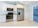 Stainless steel appliances complement the kitchen's white cabinets, counters and tile flooring at 2732 Lone Feather Dr, Orlando, FL 32837