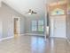 Open-concept living room featuring tiled floors, a ceiling fan and natural light from a large window at 2732 Lone Feather Dr, Orlando, FL 32837