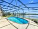 Beautiful pool with screened enclosure overlooking a serene lake, creating a tranquil backyard oasis at 2732 Lone Feather Dr, Orlando, FL 32837