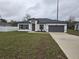 Charming single-story home with gray roof, and a two car garage, featuring a modern design and new landscaping at 2987 Sw 140Th Loop, Ocala, FL 34473