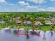 Aerial view of a beautiful waterfront home showcasing its private beach access and lush surroundings at 303 Waterwood Dr, Yalaha, FL 34797