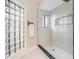 Modern bathroom with a tiled shower and unique glass block window at 303 Waterwood Dr, Yalaha, FL 34797