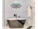 Modern bathroom showcasing a luxurious freestanding bathtub with a sleek, black faucet and decorative wall art at 303 Waterwood Dr, Yalaha, FL 34797