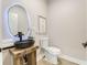 Unique powder room showcasing a custom wooden vanity with vessel sink and a modern, lighted mirror at 303 Waterwood Dr, Yalaha, FL 34797