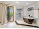 Bathroom featuring modern soaking tub, tiled shower with dual heads, and natural light from windows at 303 Waterwood Dr, Yalaha, FL 34797