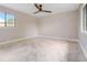 Spacious bedroom with neutral walls, carpet, ceiling fan, and a bright window with outdoor views at 303 Waterwood Dr, Yalaha, FL 34797
