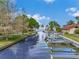Picturesque canal featuring boat docks, lush landscaping, and waterfront access at 303 Waterwood Dr, Yalaha, FL 34797