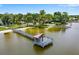 Picturesque dock with a gazebo and sandy beach access on the waterfront with mature trees at 303 Waterwood Dr, Yalaha, FL 34797