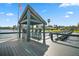 Waterfront dock featuring a covered seating area with chairs and views of the serene lake at 303 Waterwood Dr, Yalaha, FL 34797