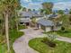 Stunning lakefront property with lush landscaping, a circular driveway, and an attached three-car garage at 303 Waterwood Dr, Yalaha, FL 34797