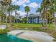 Stunning back of property with views of lush green backyard and private beach with dock access to the water at 303 Waterwood Dr, Yalaha, FL 34797