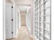 Well-lit hallway with wood floors and decorative glass blocks, providing a bright and airy feel at 303 Waterwood Dr, Yalaha, FL 34797
