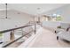 Bright hallway showcasing black railing, carpet floors, and sunlit windows, creating an inviting space at 303 Waterwood Dr, Yalaha, FL 34797