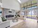 Spacious living room with a fireplace, a large window showcasing serene waterfront views and great natural light at 303 Waterwood Dr, Yalaha, FL 34797