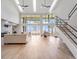 Bright living room with water views, modern stairs, and vaulted ceilings at 303 Waterwood Dr, Yalaha, FL 34797