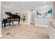 Elegant space featuring a grand piano, neutral decor, and modern art for a sophisticated living area at 303 Waterwood Dr, Yalaha, FL 34797