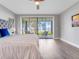 Bright main bedroom with sliding glass doors leading to an outdoor seating area overlooking the water at 303 Waterwood Dr, Yalaha, FL 34797